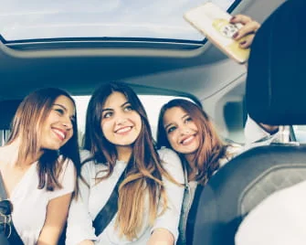 Trois femmes prenant un selfie dans une voiture.